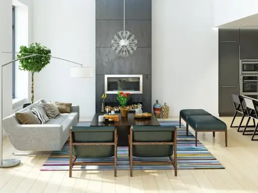 Nowoczesne wnętrza: szara sofa, kominek, designerskie fotele i kuchnia. Różne style wnętrz w jednym, przestronnym salonie.