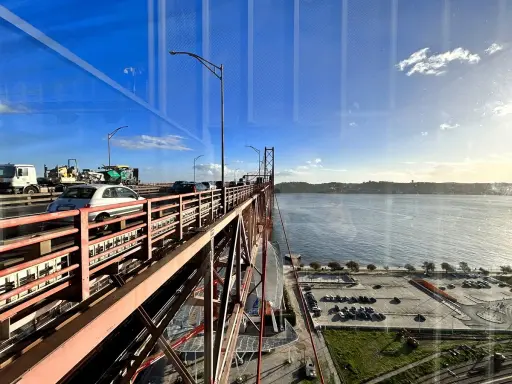 Autobahnverkehr auf der Brücke in Lissabon, mit Blick auf den Tejo und einen Parkplatz neben Pilar 7.