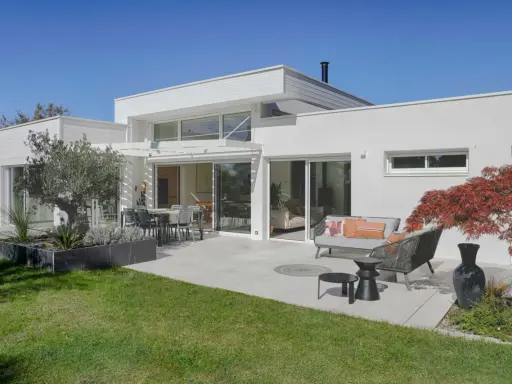 Maison moderne avec extension, terrasse aménagée. L'extension maison architecte obligatoire a créé un espace de vie lumineux et spacieux.
