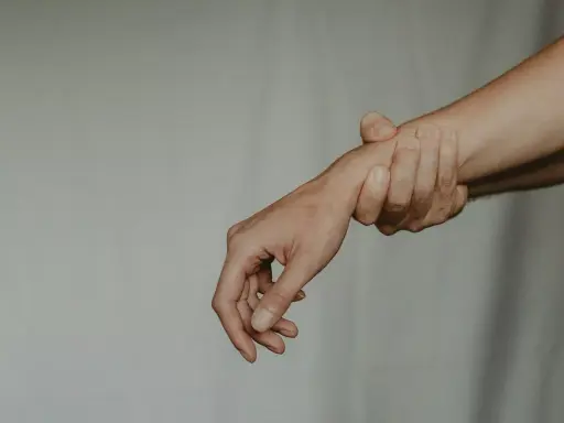 Dłoń trzymająca inną dłoń za nadgarstek. Zaborcza osoba nie chce puścić.