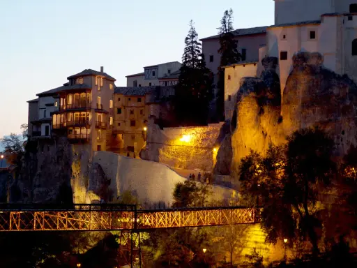 El puente de San Pablo en Cuenca, iluminado de noche, conecta las casas colgantes con la ciudad.