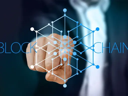 Dłoń wskazująca na sieć połączonych węzłów, symbolizującą blockchain w logistyce.