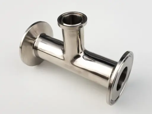Un raccord clamp en acier inoxydable, en forme de T, prêt à être assemblé pour un système de tuyauterie.