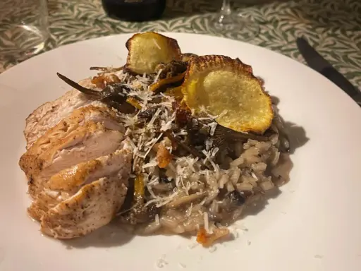 En krämig svamprisotto med skivad kycklingfilé och krispiga potatisskal. Ett perfekt risotto recept för en mysig middag.
