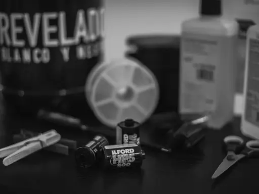 Utensilios para revelar fotos en blanco y negro: carretes Ilford, tijeras, pinzas y botes de químicos.