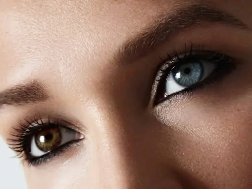 Oczy z heterochromią centralną: jedno niebieskie, drugie brązowe. Makijaż podkreśla ich niezwykły urok.