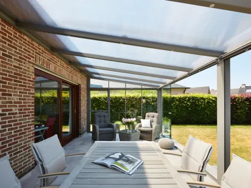 Une pergola moderne avec toit transparent, parfaite pour installer un salon extérieur confortable.
