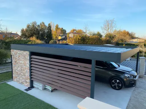 Un carport moderne avec un toit plat, idéal pour comment couvrir un carport toit plat. Une voiture y est garée.