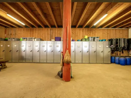 Reihe von Spinden, ideal zum Sattelschrank organisieren. Besen lehnen an rotem Pfosten.