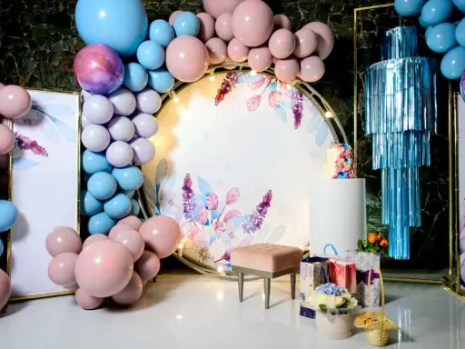 Jak udekorować salę na 18 urodziny? Balony, kwiaty i elegancka ścianka z motywem roślinnym stworzą magiczną atmosferę.