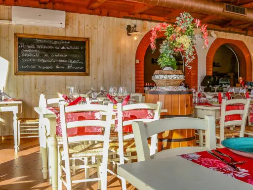 Interno di un ristorante di carne a Rimini centro, con tavoli apparecchiati e un menu scritto a mano.