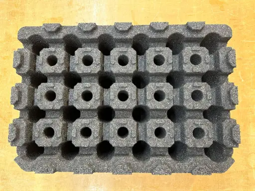 Graues epp kunststoff-Material mit vielen kleinen, quadratischen Hohlräumen, das wie eine Schachtel für empfindliche Gegenstände aussieht.