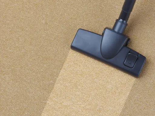 Cabezal de aspiradora limpiando una alfombra beige. El proceso de como limpiar una alfombra es sencillo con esta herramienta.