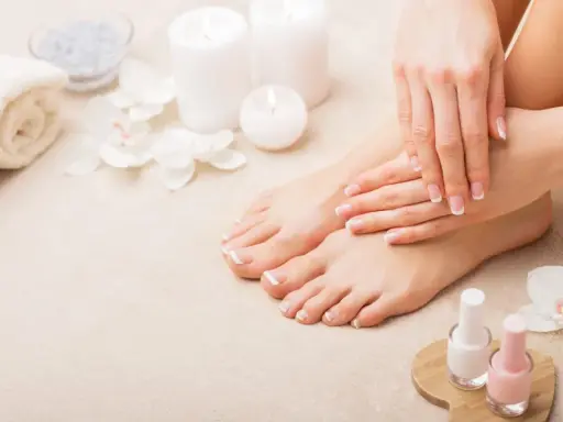 Piedi curati e mani perfette: il podologo fa la pedicure, con smalti rosa e bianchi pronti per un tocco finale.