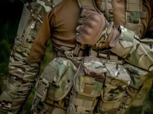 Żołnierz w mundurze moro, z rękawiczkami taktycznymi. Wytrzymałość materiału, czy to cordura 500 czy 1000, jest kluczowa w terenie.
