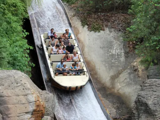 Bootsfahrt auf einer Wildwasserbahn, die durch eine üppige, grüne Landschaft führt. Die Menschen lachen und genießen die Fahrt auf der Isla Mágica.