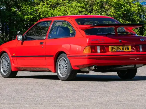 Roter Ford Sierra RS Cosworth mit großem Heckspoiler und markanten Felgen, bereit für die nächste Ausfahrt.