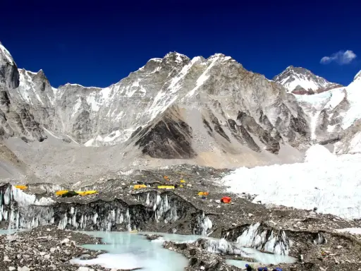 Niezwykły widok z bazy pod Mount Everest. Kolorowe namioty obozowe na tle lodowca i surowych, ośnieżonych szczytów. To początek ekscytującego **trekking pod Mount Everest**.