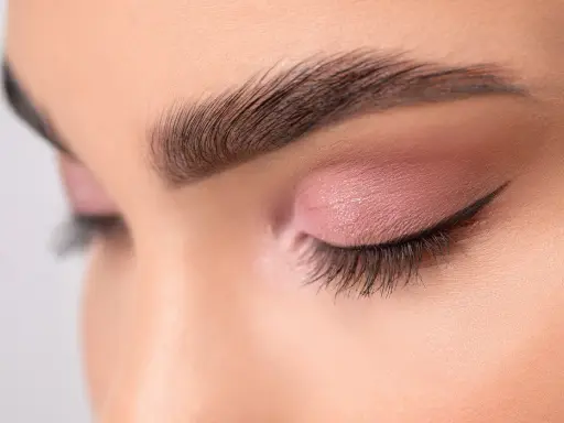 Ojo cerrado con sombra rosa y delineado fino, mostrando diferentes tipos de raya del ojo.