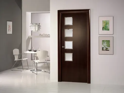 Puerta wengue con marcos de cristal. Paredes claras y un rincón de comedor moderno.