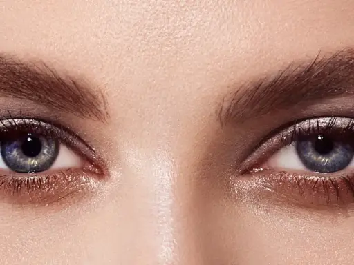 Ojos con un cautivador maquillaje con sombras azules y plateadas, realzados por pestañas largas y definidas.