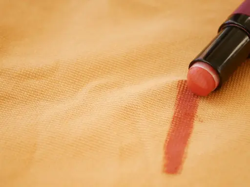 Rossetto su tessuto color pesca, un esempio pratico su come togliere il fondotinta dai vestiti.