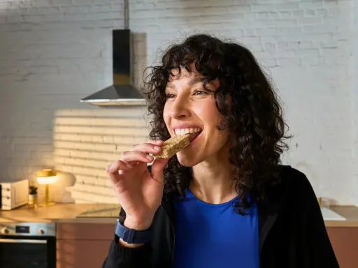 Frau isst einen Riegel, die perfekte Energie für das, was essen vor dem Training.