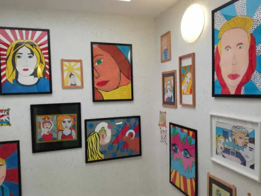 Bunte Pop-Art-Bilder, entstanden im Kunstunterricht, zieren die Wand. Porträts von Frauen im Comic-Stil, kräftige Farben und Linien.