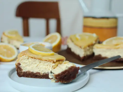 Tranches de cheesecake au citron, garnies d'une tranche de citron frais. Parfait pour une recette coulis de citron pour cheesecake.
