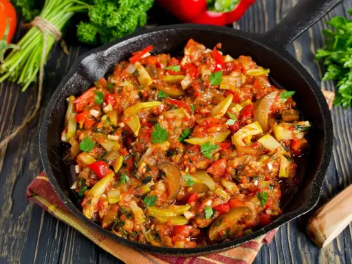 Poêlée de légumes colorée, une spécialité Côte d'Azur, avec courgettes, poivrons et tomates, garnie de persil frais.