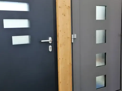 Dwie nowoczesne drzwi wejściowe, ciemnoszare i szare, z przeszkleniami. Ocieplenie drzwi wejściowych to klucz do komfortu.