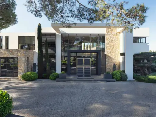 Une villa moderne avec des pierres apparentes et de grandes baies vitrées, parfaite pour construire une maison bioclimatique.