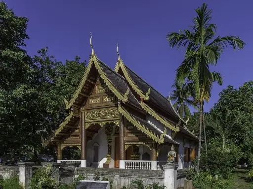 Złocone zdobienia świątyni w Chiang Mai, otoczonej bujną zielenią, to jedna z pięknych atrakcji miasta.