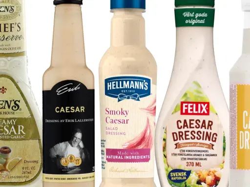 Flera flaskor med caesarsallad dressing, inklusive Ken's, Hellmann's och Felix.
