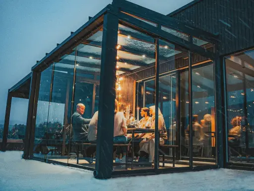 Gemütliches Abendessen im Glasanbau. Die Frage "was kostet ein Wintergarten" stellt sich hier angesichts der Atmosphäre nicht.