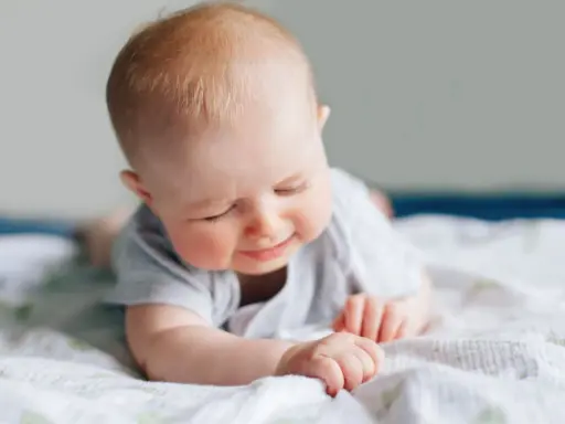 Ein süßes Baby liegt auf dem Bauch, die Augen geschlossen, als würde es die Welt entdecken. Ein Zeichen des baby 6 wochen wachstumsschub.