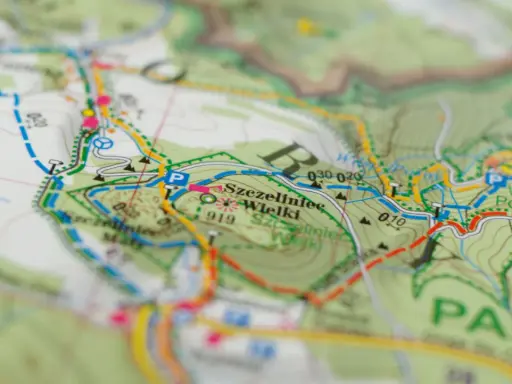 Mapa turystyczna z zaznaczonym szlakiem czerwonym, który oznacza najdłuższą trasę. Widoczne nazwy miejscowości i terenów.
