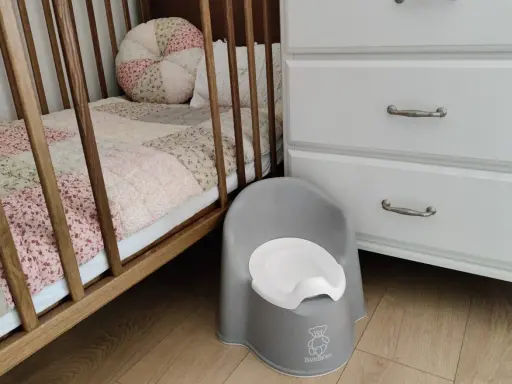 Szara nocniczka BabyBjörn obok łóżeczka. Czas na rozwiązanie problemu z odpieluchowaniem 3 latka.