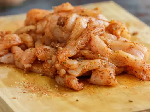 Tiras de pollo crudo sazonadas, listas para preparar unas deliciosas fajitas de pollo.