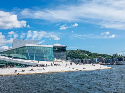 Ein sonniger Tag für Oslo Sightseeing am Opernhaus mit seiner einzigartigen Architektur und dem Wasser.