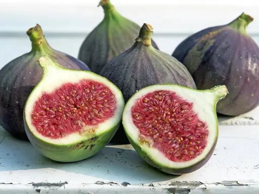 Frische Feigen, eine aufgeschnitten, zeigen ihr saftiges Inneres. Sie sind feigen gesund und ein Genuss.