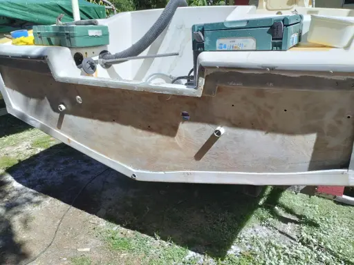 Préparation pour refaire le tableau arrière d'un bateau. Des outils et des matériaux sont visibles.