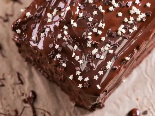 Ein köstlicher schoko kuchen mit glänzender Glasur und Sternenstreuseln. Perfekt für jeden Anlass, der Glück bringt.