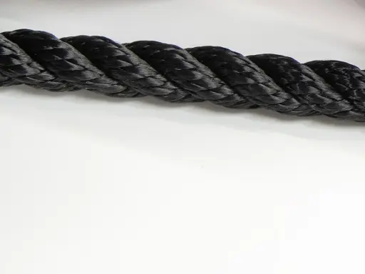 Gros cordage noir tressé, prêt à sécuriser un navire lors de sa prochaine traversée.