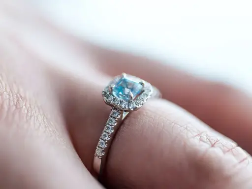 Un anello di fidanzamento con un acquamarina centrale e diamanti, simbolo di un amore eterno e profondo.