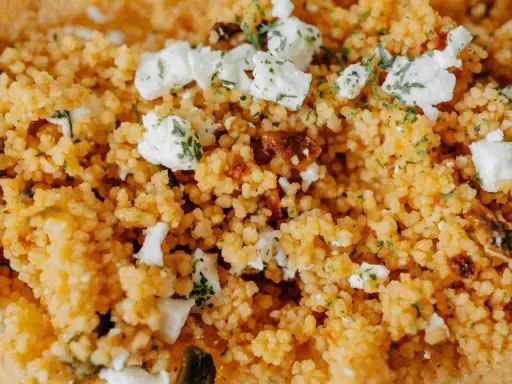 Couscous aux morceaux de feta et herbes. La différence semoule et couscous est subtile, mais ici, le couscous est prêt à être dégusté.