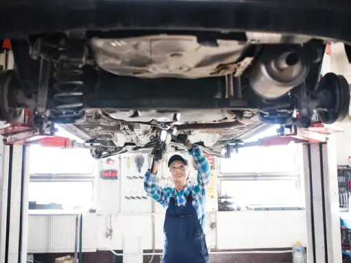 Mecánica revisa el coche en elevador. ¡Un buen comienzo para abrir taller mecánico!