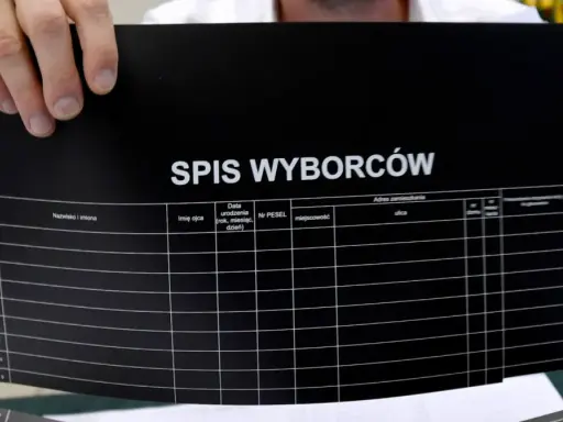Ręce trzymają czarny arkusz z napisem "SPIS WYBORCÓW". Widać kolumny do wpisania danych, co może pomóc w procesie jak zmienic miejsce glosowania.