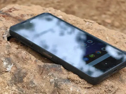 Telefon CAT najnowszy, wytrzymały, leży na kamieniu.