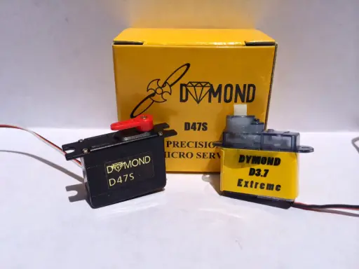 Zwei Servos, ein schwarzer Dymond D47S und ein gelber Dymond D3.7 Extreme, stehen vor einer gelben Box mit der Aufschrift "Dymond D47S".